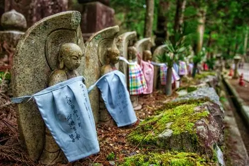 Кладбище Окуноин в Коясане, Япония. Несколько небольших каменных статуй, завернутых в ткань, посреди леса.
