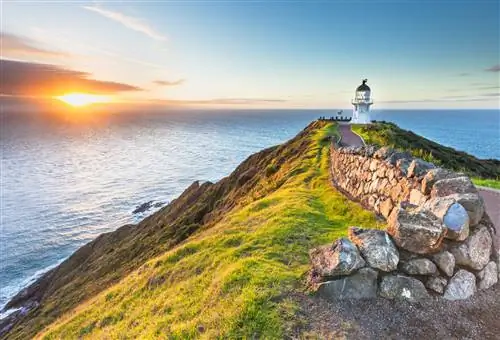 Маяк Cape Reinga с заходящим солнцем в Новой Зеландии