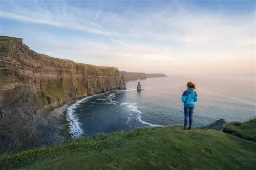 Ирландия, графство Клэр, Лахинч: туристы смотрят на величественные скалы Мохер на закате поздней весной.