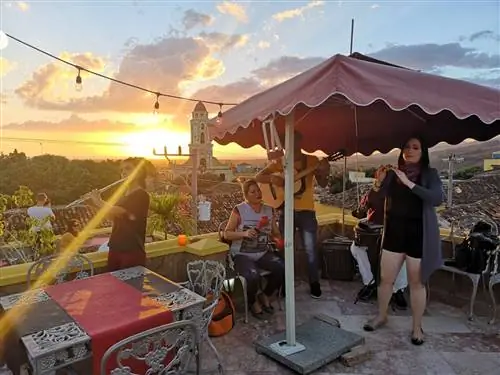 Группа сальсы выступает в кафе на крыше на закате в Тринидаде, Куба.