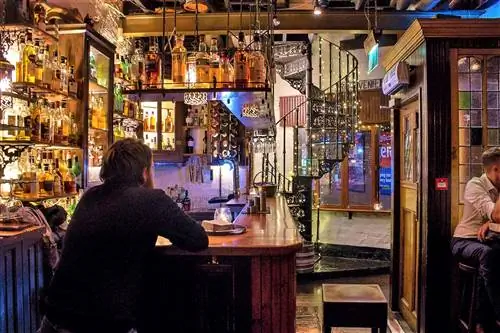 Мужчина наслаждается напитком в баре паба Wee.