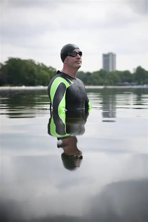 Мужчина в гидрокостюме стоит в The Serpentine, Лондон.