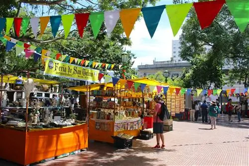 Люди просматривают прилавки на антикварном рынке во время Feria de San Pedro Telmo в Буэнос-Айресе.
