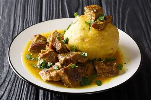 Острый мофонго с бананами, чесноком и чичарроном подается с мясом и бульоном крупным планом на столе. горизонтальный