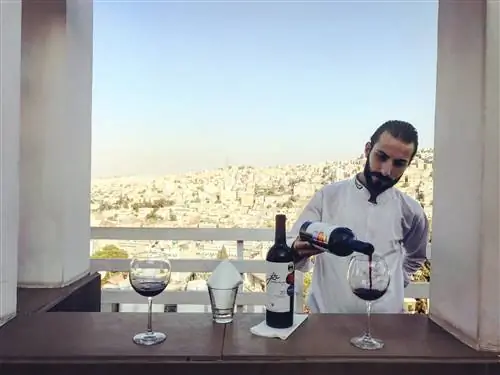 Бармен наливает стакан местного пива Jordan River Shiraz с видом на Амман с верхней террасы Cantaloupe. Бармен наливает стакан местного пива Jordan River Shiraz с видом на Амман с верхней террасы Cantaloupe.