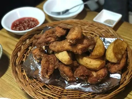 Корзина с жареной курицей по-корейски и картофельными дольками с блюдом из красного соуса для макания
