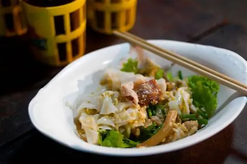 Блюдо gooay teeo kooa gai, рисовой лапши, обжаренной с курицей и яйцом, продается в китайском квартале Бангкока.