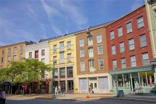 Несколько человек идут перед красочными фасадами на изогнутой улице Antiques Row на River Street в центре Трои. Несколько человек идут перед красочными фасадами на изогнутой улице Antiques Row на River Street в центре Трои.