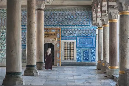 Женщина, идущая по богато украшенному кафельным интерьером дворца Топкапы, Стамбул