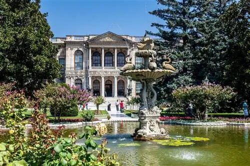 Красивый фонтан и сады перед дворцом Долмабахче в Стамбуле, Турция