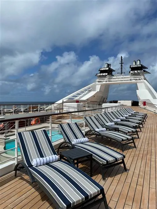 Пляжные лежаки у борта круизного лайнера.