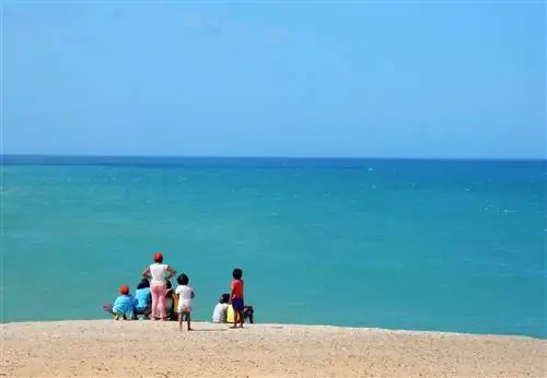 Семья смотрит на океан на полуострове Ла-Гуахира, Колумбия.