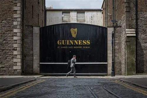 Мужчина проходит мимо знаменитых ворот пивоварни Guinness в Дублине.