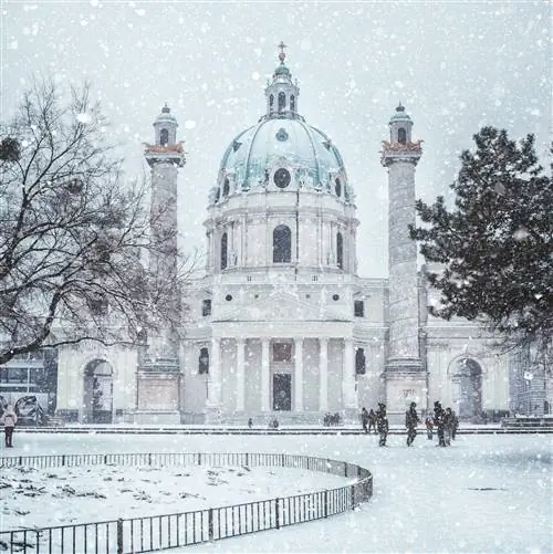 Внешний вид барочной церкви Святого Карла (Karlskirche), покрытой снегом.