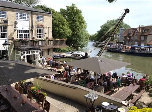 The Head of the River Pub, Оксфорд. В пабе на берегу реки есть пивной сад, где люди пьют и общаются.