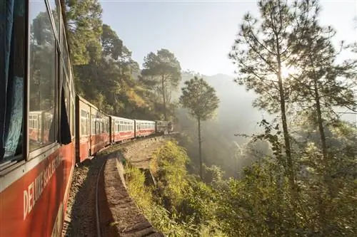 Поезд Shivalik Deluxe Express из Калки в Шимлу завершает свой путь. Железнодорожная линия очень живописна, она проходит по склону горы и окружена лесом.