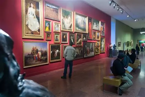 Посетители рассматривают картины на стенах Венгерской национальной галереи в Будайском замке, Будапешт.