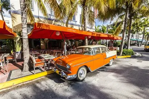 Отель Edison в стиле ар-деко и классический автомобиль Oldsmobile на Ocean Drive, South Beach, Майами, США. Классическим автомобилям разрешено парковаться на желтой линии.