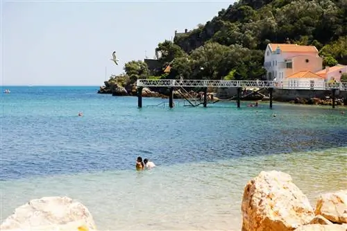 Люди плавают в воде на пляже в Parque Natural da Arrábida, Сетубал, Португалия, Европа