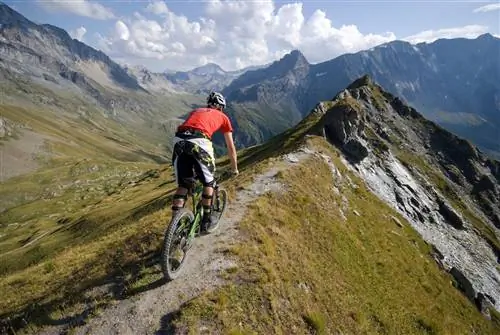 Горный велосипедист едет по гребню недалеко от Лез-Арк во французских Альпах.