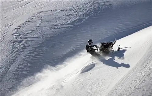 Снегоход поднимается по крутому склону в Монтане