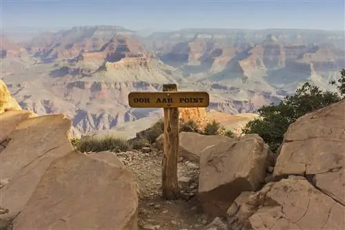 Деревянный знак Ooh Aah Point в центре изображения, откуда открывается вид на огромный Гранд-Каньон.