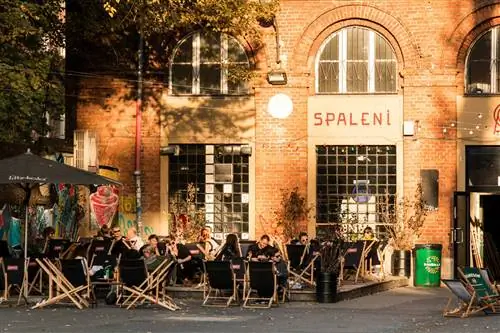 Посетители бара наслаждаются напитками на шезлонгах возле модного Spaleni Słońcem, коктейль-бара в OFF Piotrkowska.