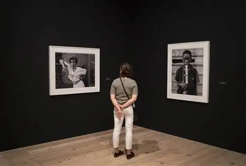 Посетитель музея наблюдает за черно-белыми фотографиями в Музее американского искусства Уитни.