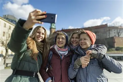 Семейная экскурсия по городу Кракову, Польша, в межсезонный зимний день. Семья фотографируется на площади возле замка Вавель
