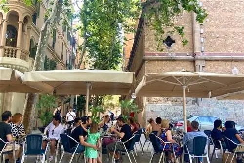 Семьи отдыхают на площади в Грасиа