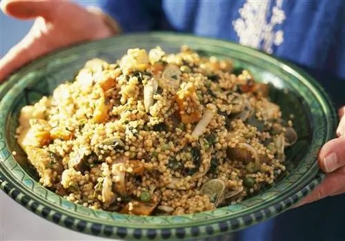 Человек, держащий зеленое блюдо из овощного кускуса