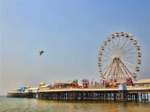 Альтернативы Диснея - пирс Blackpool Pleasure Beach. Огромное колесо обозрения торчит в ясном голубом небе, когда мимо пролетает чайка.