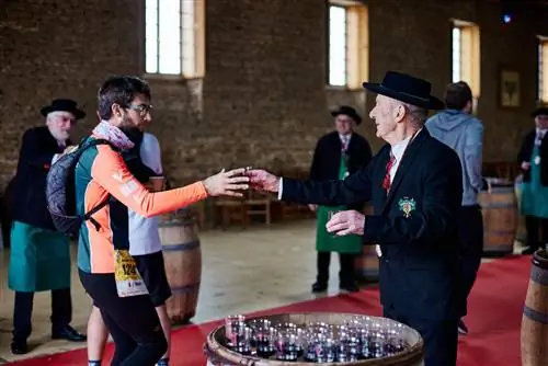 Участники марафона Beaujolais Wine Marathon наслаждаются бокалом вина после забега