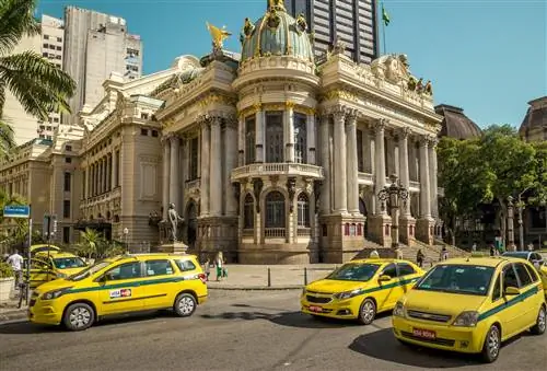 Улица полна машин такси с муниципальным театром на заднем плане в Рио-де-Жанейро, Бразилия.