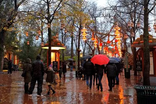 Люди в дождливый день гуляют по саду Тиволи, Копенгаген