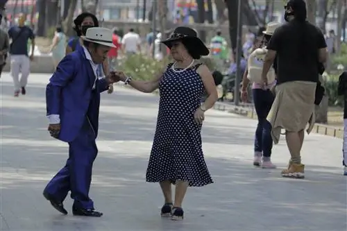 Две танцовщицы танцуют в Центральном районе Аламеда недалеко от Сокало в Мехико.