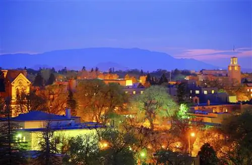 Снимок малоэтажного городка в сумерках. На небе, где недавно зашло солнце, видны розовые полосы света.