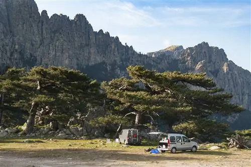 Пейзаж Bavella Needles (Les Aiguilles de Bavella) с заезжими автомобилями Пейзаж Bavella Needles (Les Aiguilles de Bavella) с заезжими автомобилями
