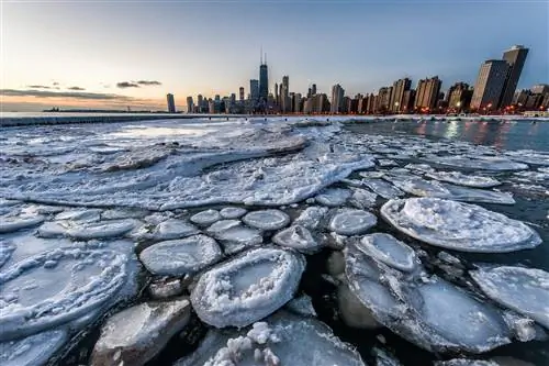 Лед на озере с горизонтом большого города с высокими небоскребами на заднем плане