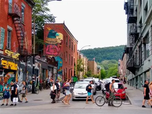 Люди ходят, ездят на велосипеде и едут по причудливой улице в Монреале.