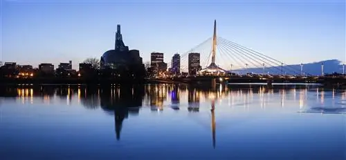 Особенности - Канада, Манитоба, Виннипег, Освещенный горизонт, отражающийся в спокойной реке Ассинибойн.