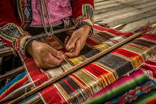 Крупный план рук женщины, плетущей одеяло в Перу