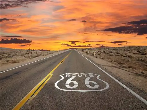 Оранжевый закат над дорогой, нарисованной символом Route 66.