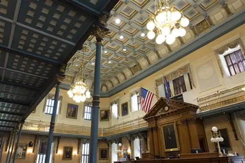 Интерьер Сенатской палаты Государственного дома Южной Каролины в Колумбии с большим свисающим флагом США.