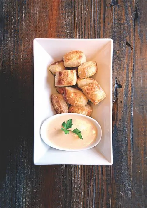 Фондю из сыра пименто в белом фарфоровом блюде на деревенском деревянном столе в Августе, Джорджия