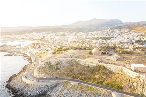 Вид с воздуха на старую крепость на холме с дорогой вдоль побережья