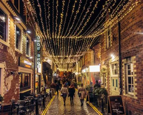 Люди на вечеринке в Эштон-лейн, переулке в Глазго, полном баров и ресторанов.