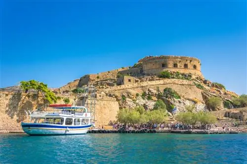 Вид на остров Спиналонга со спокойным морем и высадкой пассажиров с парома