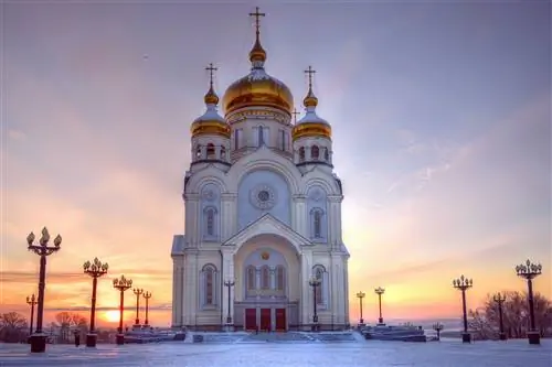 Огромная белая церковь с тремя золотыми куполами на крыше