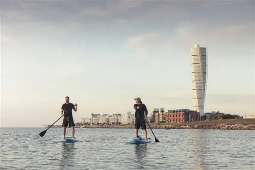 Два друга катаются на байдарках перед башней Turning Torso.